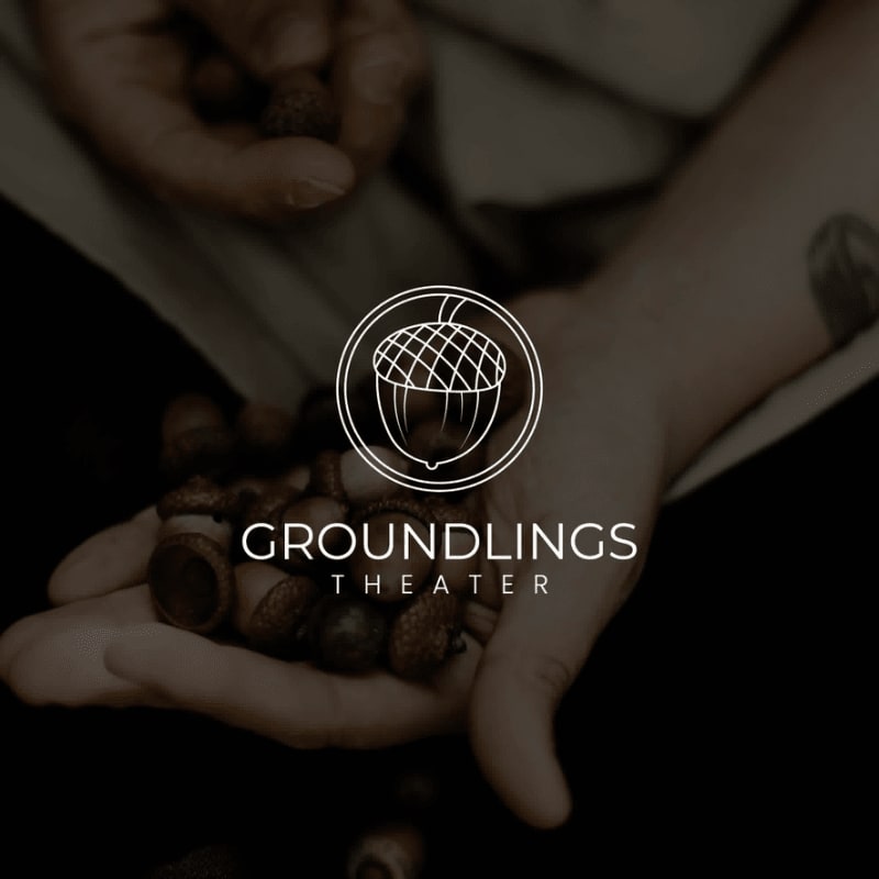 A close-up of cupped hands holding acorns is set against a dark, blurred background, with a circular logo featuring an acorn and the text "GROUNDLINGS THEATER" superimposed.