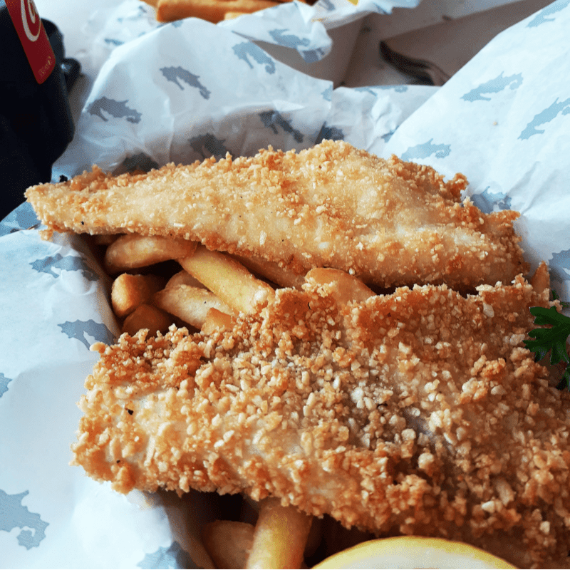 A fish and chips meal with a soda