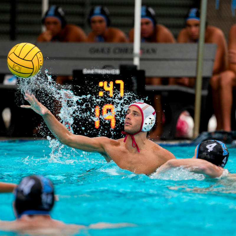 Water polo player throws ball during game.