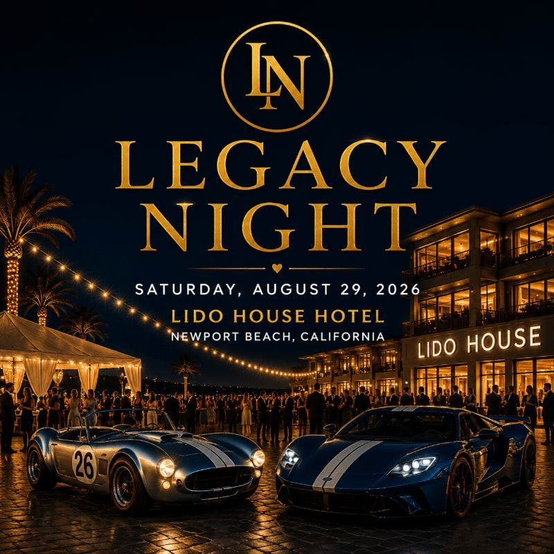 Two classic sports cars are parked in front of a brightly lit hotel at night, with a crowd gathered under a tent in the background.