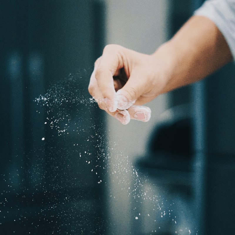 person holding water droplets on glass