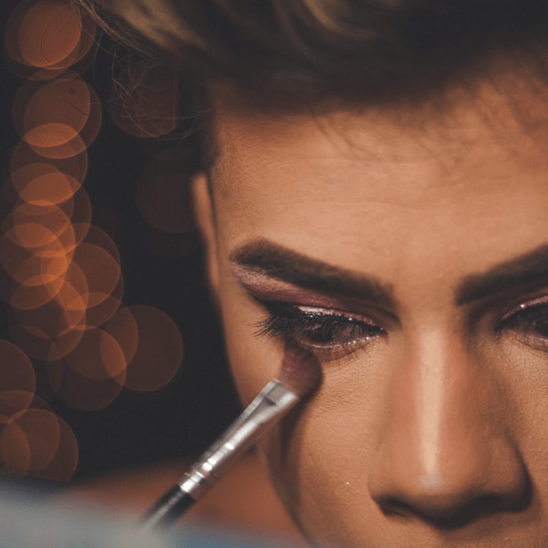 a close up of a woman with a pen in her mouth