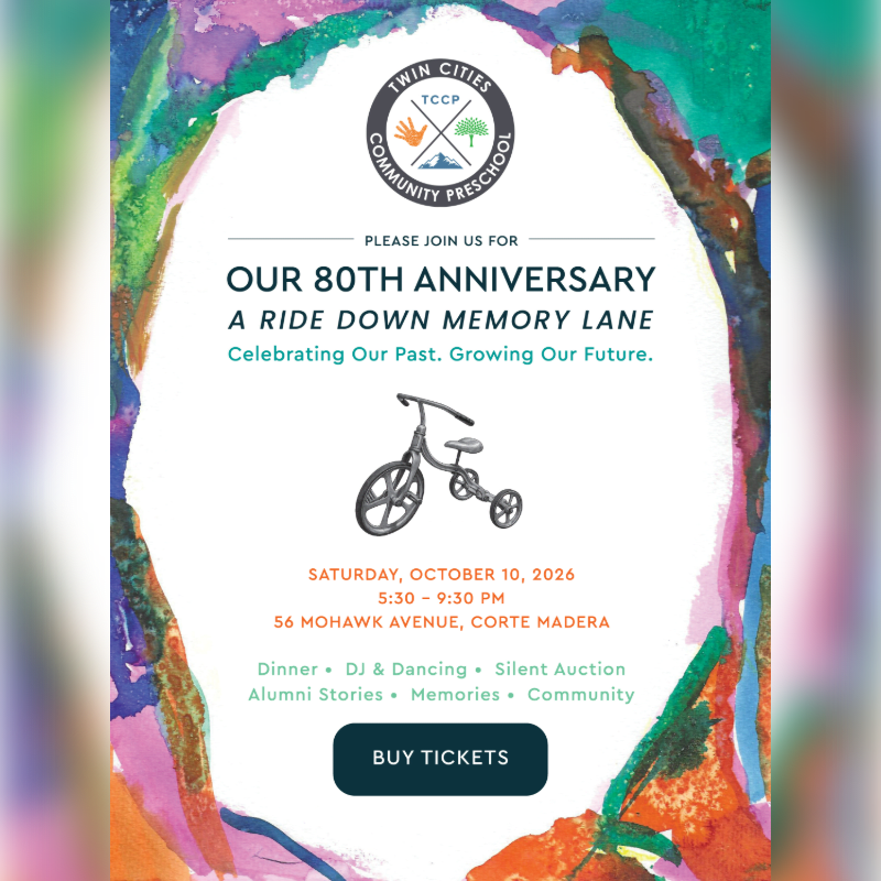 A vintage tricycle is centered on a white invitation for Twin Cities Community Preschool's 80th anniversary, framed by a colorful, abstract watercolor background.