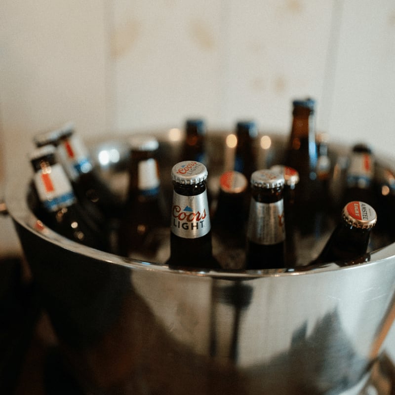 a metal bowl filled with bottles of beer