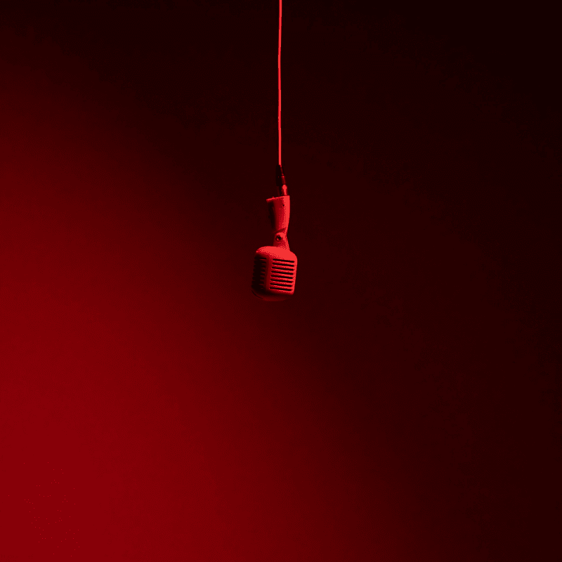 a red light bulb hanging from a red cord