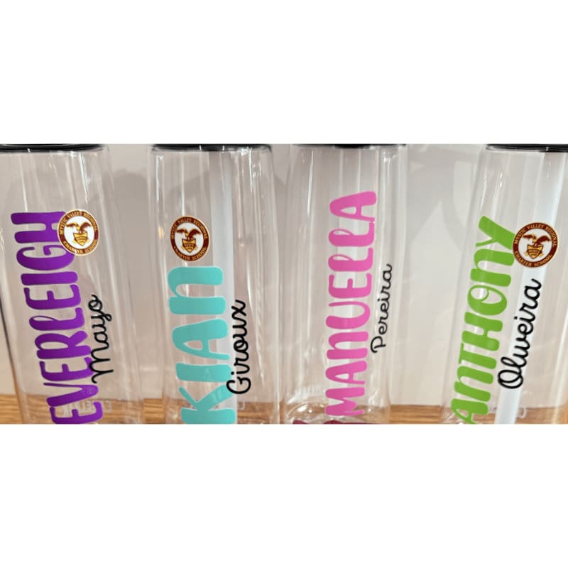 Four clear plastic cups with names in colorful lettering and a small circular logo are lined up against a white background.