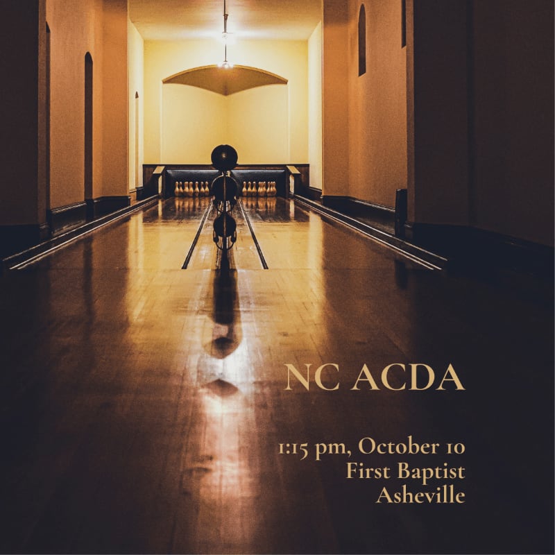 A bowling ball and pins are centered on a polished wooden lane in the foreground, leading to a dimly lit, arched hallway in the background.
