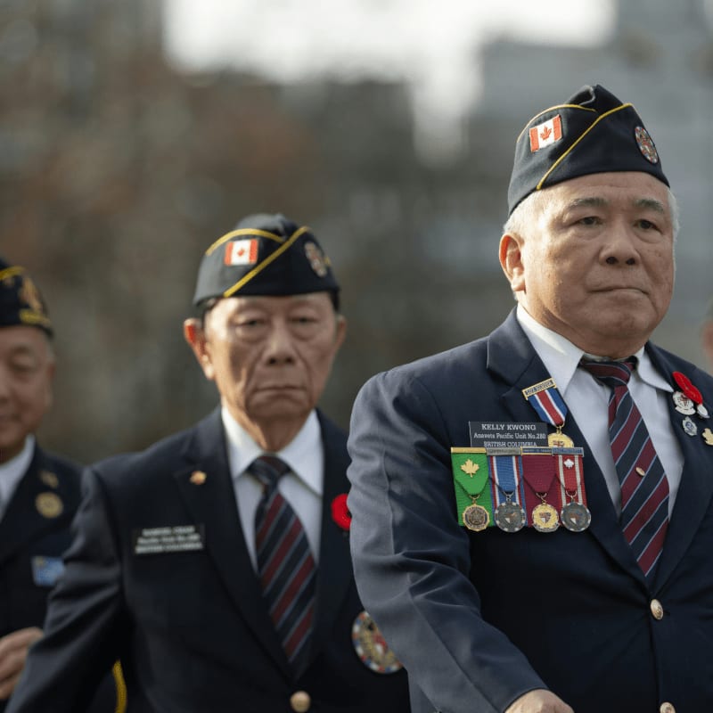 Veterans in uniform marching with medals