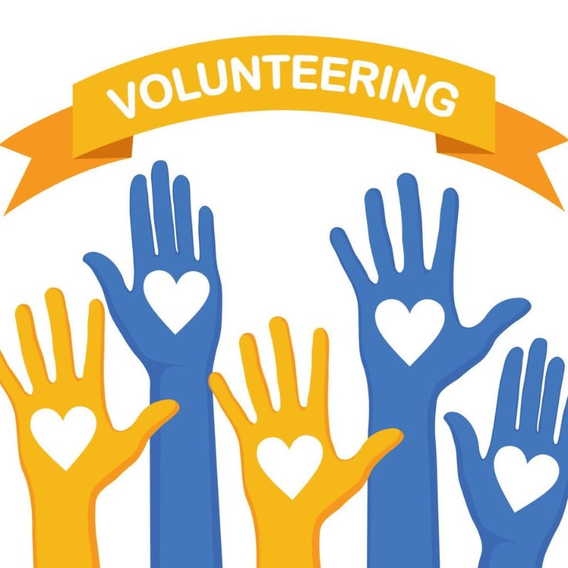 Colorful hands with hearts are raised in front of a banner that reads "VOLUNTEERING."