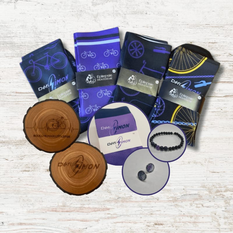 Four pairs of bicycle-themed socks, two wooden coasters, a bracelet, and two cufflinks are arranged on a light wooden surface.