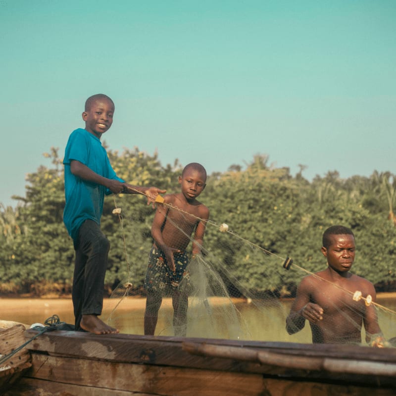 A group of men standing on top of a wooden boat