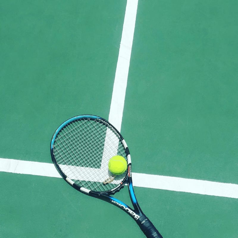 tennis racket and ball on field