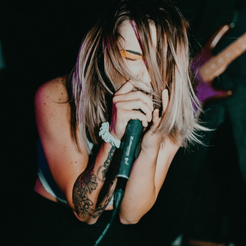 woman in blue tank top holding microphone