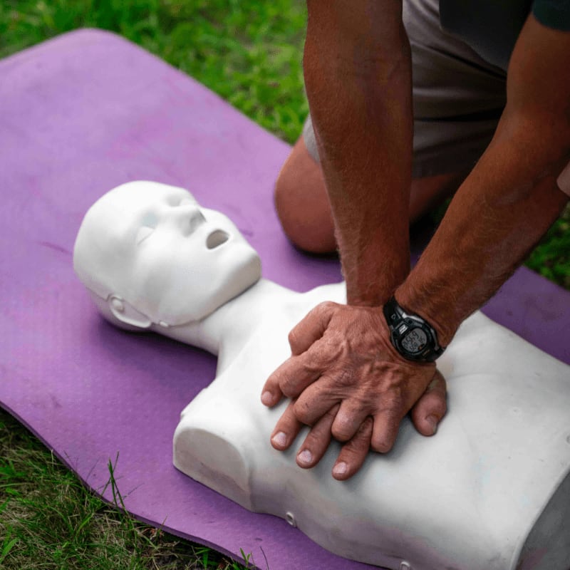 Person practicing cpr on a training dummy