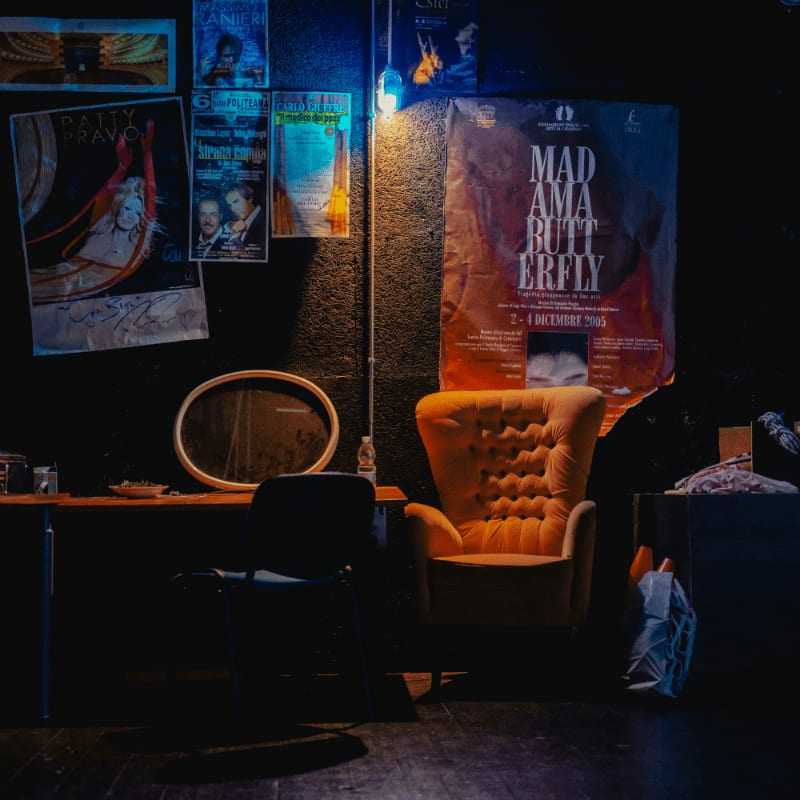 a room with a table chairs and a wall with posters on it