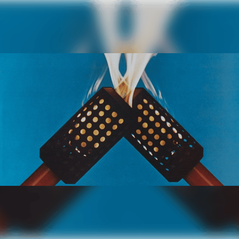 Two torches with perforated sleeves are angled towards each other, their flames merging against a vibrant blue background.