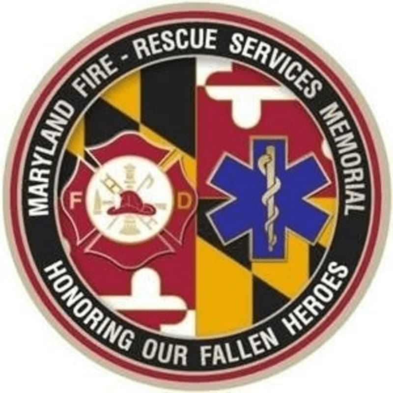 A circular emblem with the Maryland flag in the background features a Maltese cross on the left and a Star of Life on the right, with text around the border reading "MARYLAND FIRE - RESCUE SERVICES MEMORIAL HONORING OUR FALLEN HEROES."