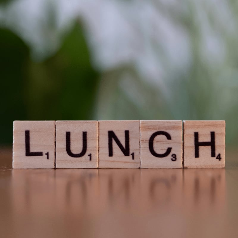 A wooden block spelling lunch on a table
