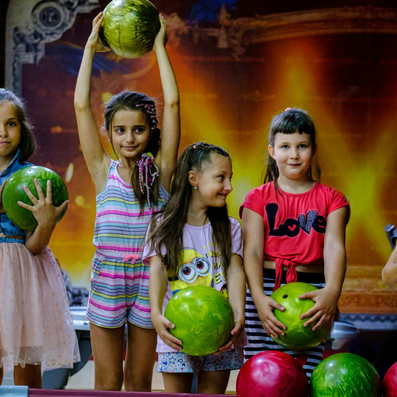 a group of children holding up bowling balls