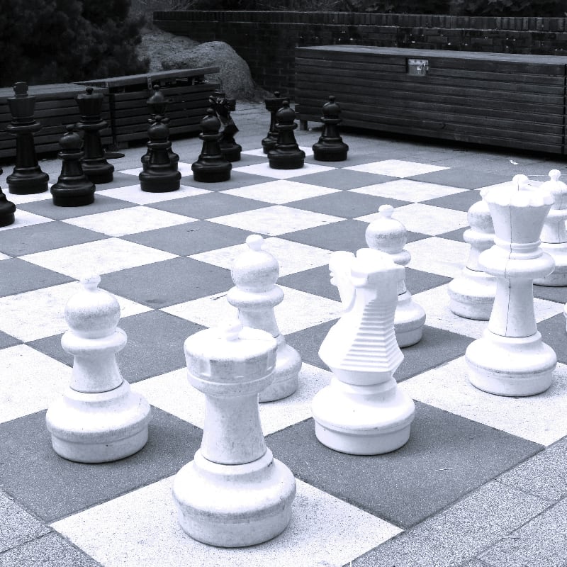 Large chess pieces set up on a checkerboard.