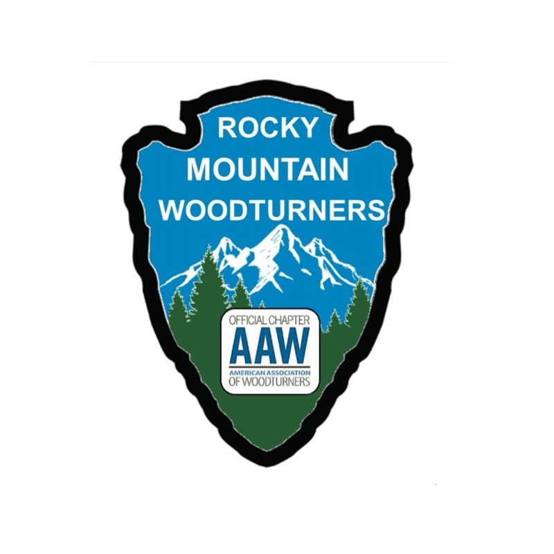 A stylized arrowhead-shaped logo features a mountain landscape with trees in the foreground and the "Rocky Mountain Woodturners" text above, with an "Official Chapter AAW" seal below.