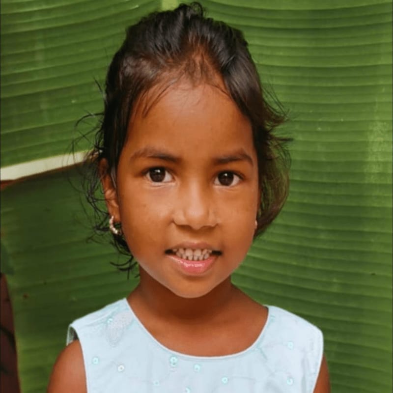 A young girl with dark hair and brown eyes smiles slightly in the foreground, while a large, textured green leaf forms the background.