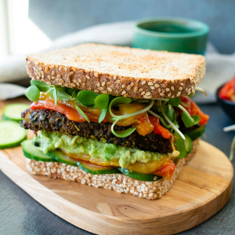 burger with lettuce and tomato on brown wooden chopping board