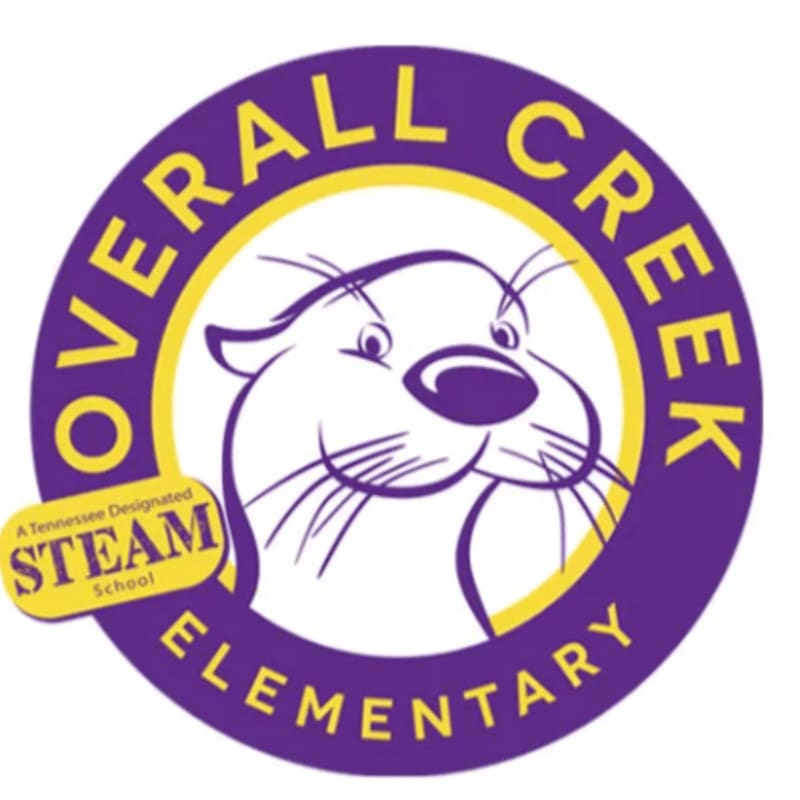 A cartoon otter's face is centered within a purple circle with yellow lettering that reads "OVERALL CREEK ELEMENTARY," and a yellow oval in the lower left corner states "A Tennessee Designated STEAM School."