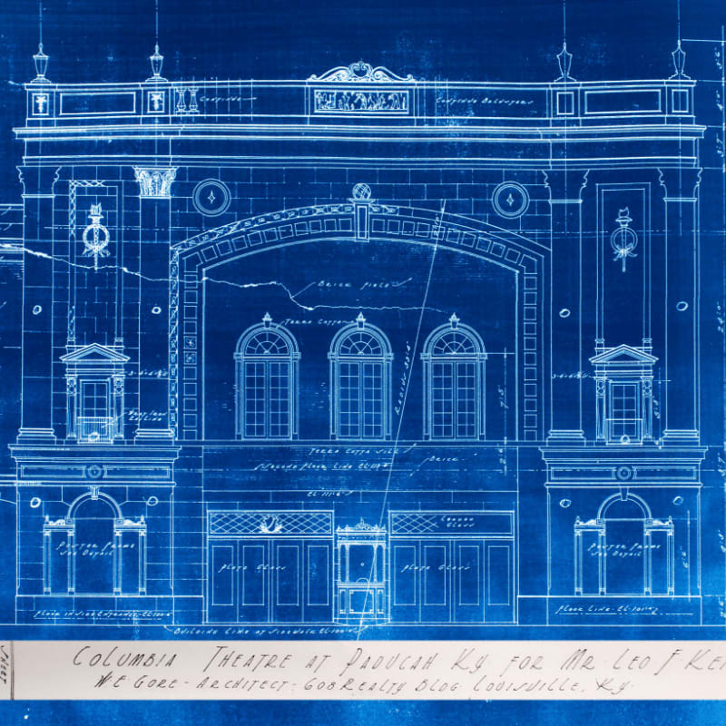 A blueprint of the Columbia Theatre in Paducah, KY, designed by H.E. Gore, features detailed architectural drawings of the facade with text at the bottom identifying the project and architect.