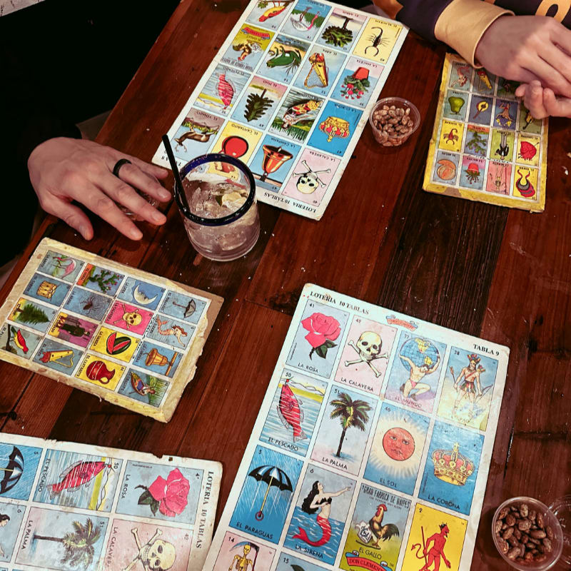 People playing loteria with drinks and snacks.