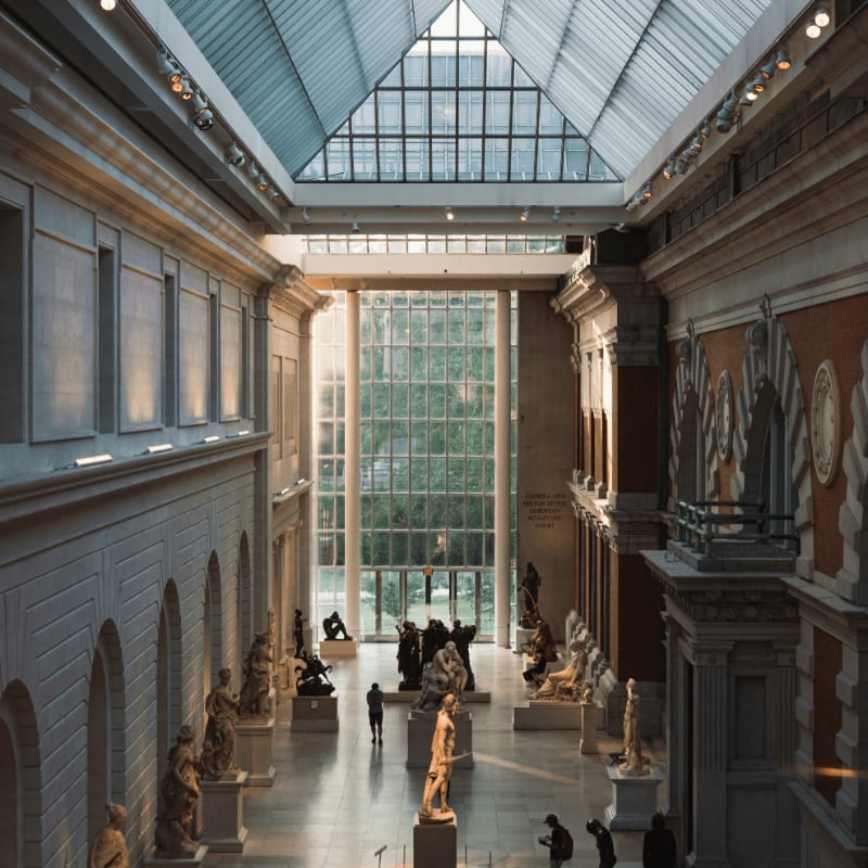 a large room with statues and people