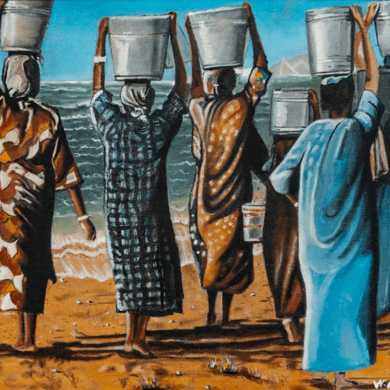 Several women carry buckets of water on their heads along a sandy beach with the ocean in the background.