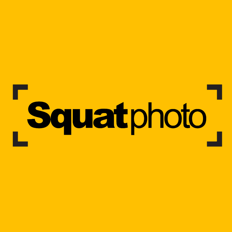 Black text spelling "Squatphoto" is centered on a bright yellow background, framed by four black corner brackets.