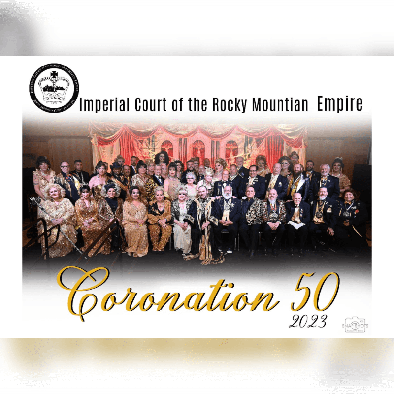 A large group of formally dressed people pose for a photo in front of a decorated backdrop, with "Coronation 50 2023" written in large script at the bottom.