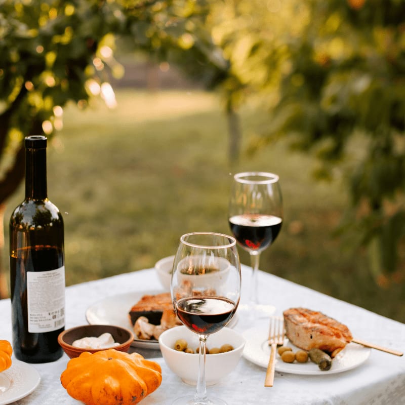 a table topped with plates of food and a bottle of wine
