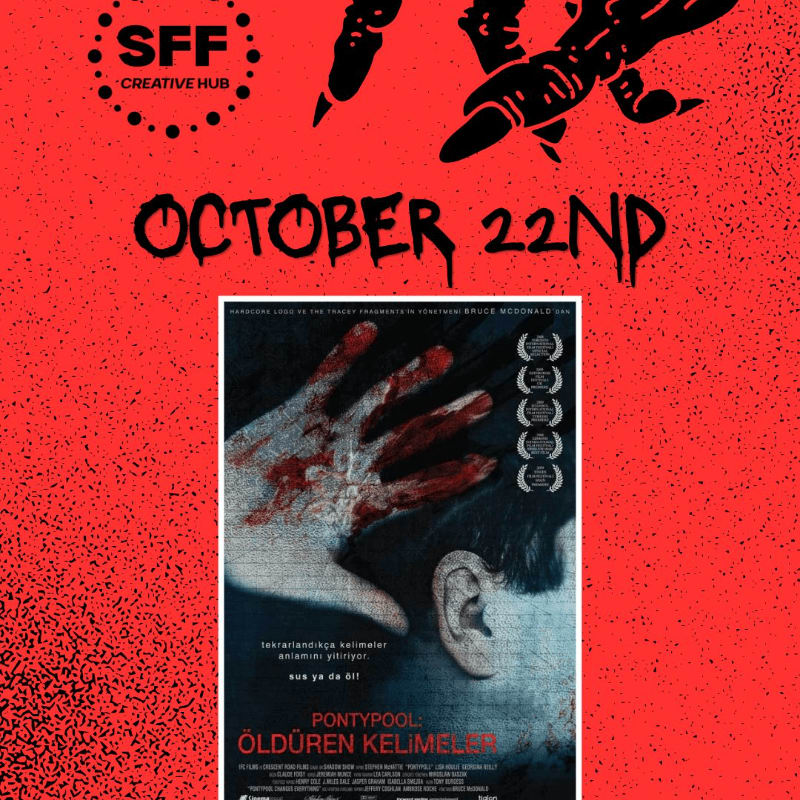 A bloody hand is held up in front of a movie poster, with a red, textured background and "OCTOBER 22ND" written in dripping letters above.