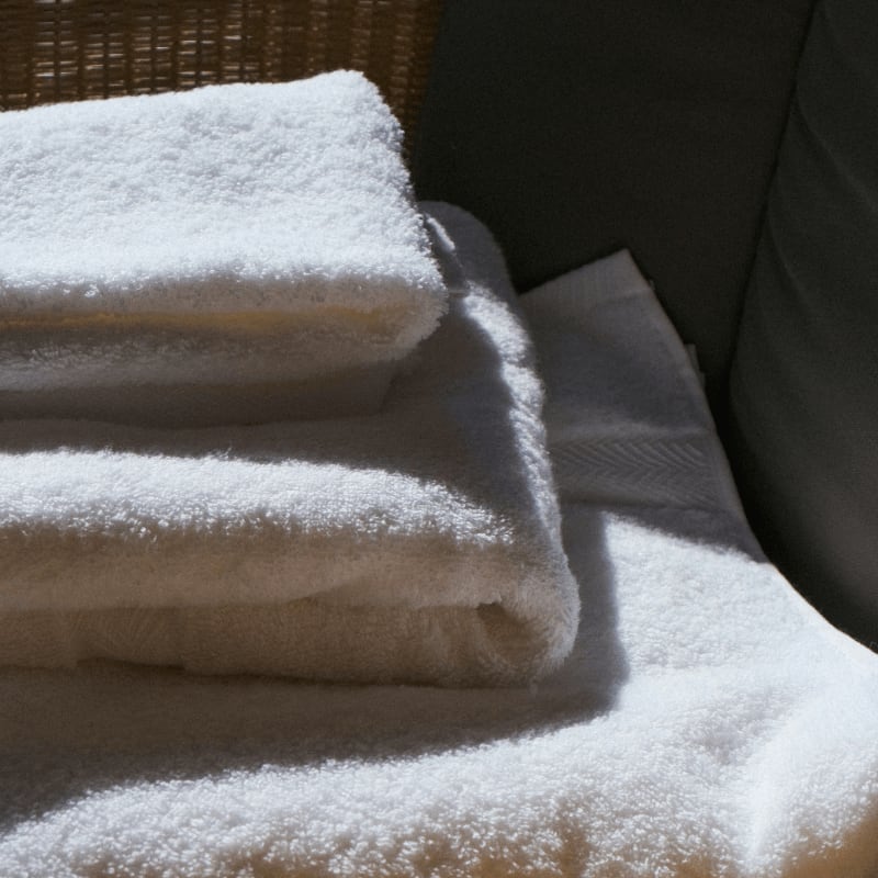 Stack of clean white towels on a surface.