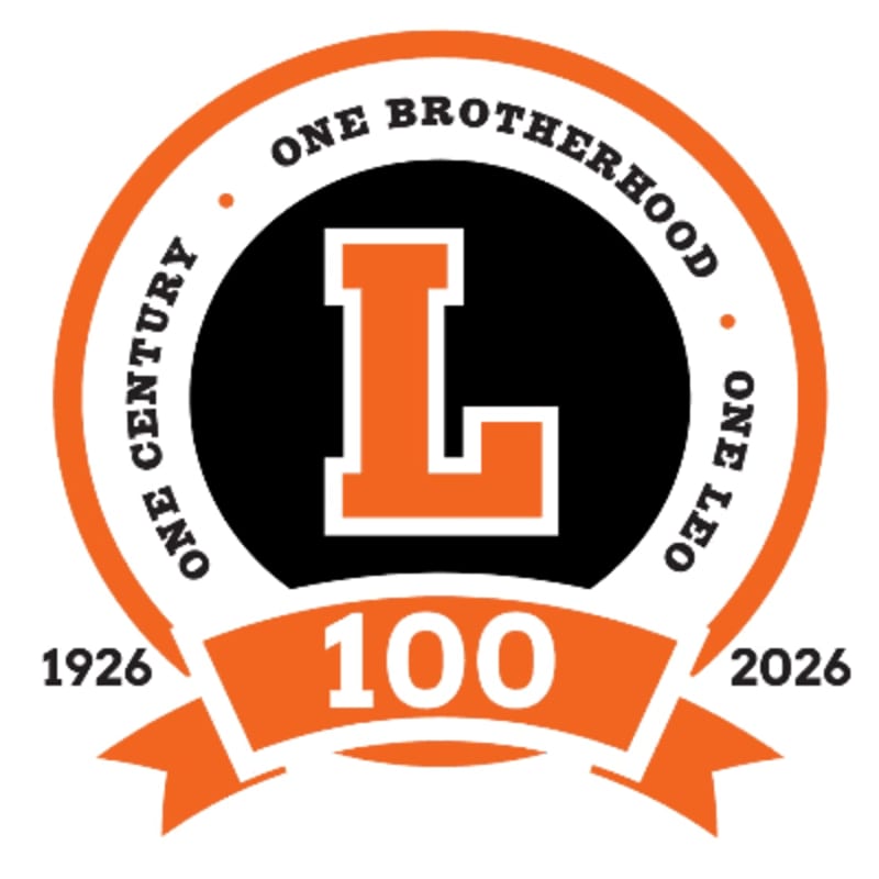 An orange and white circular logo with a black center featuring a large orange "L" is set against a white background, with a banner below displaying "100" and dates.