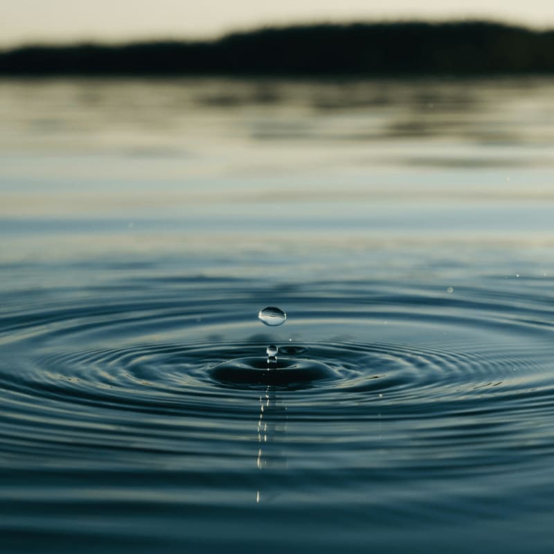 a drop of water falling into a body of water
