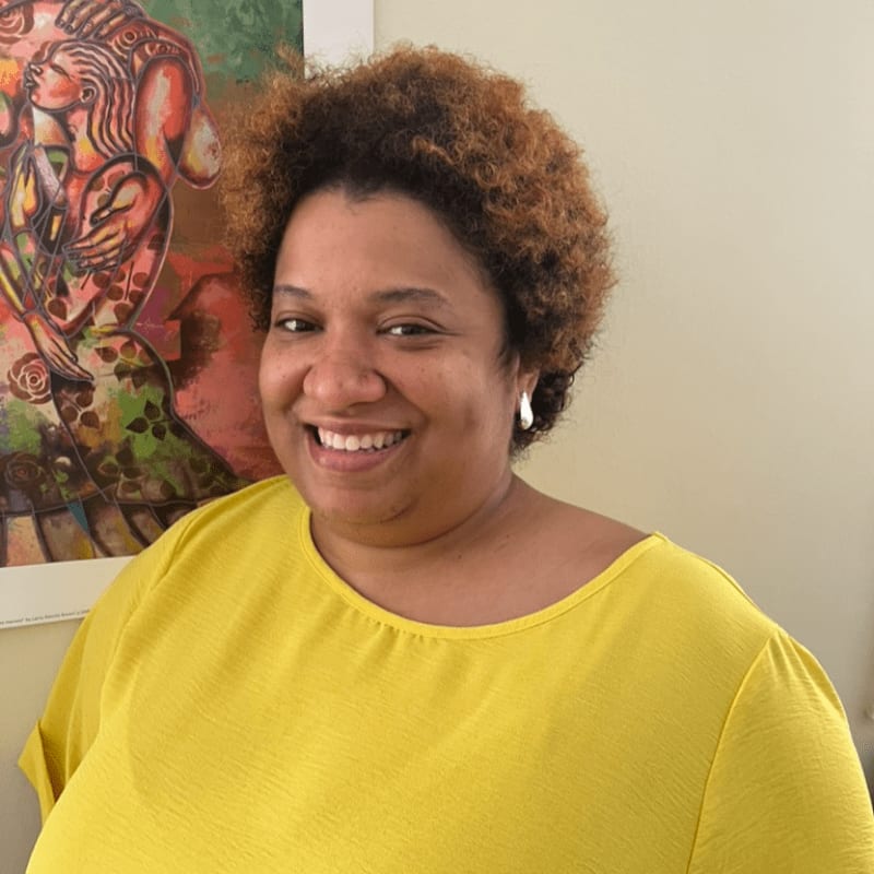 A smiling woman with community support in the background