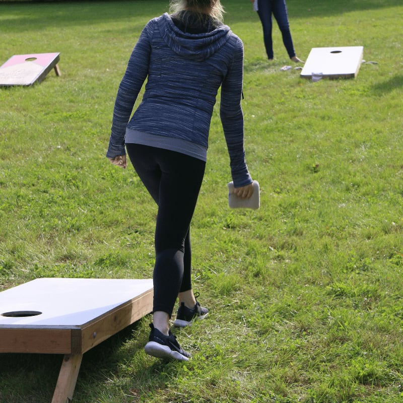 two women playing a game of bean bag toss