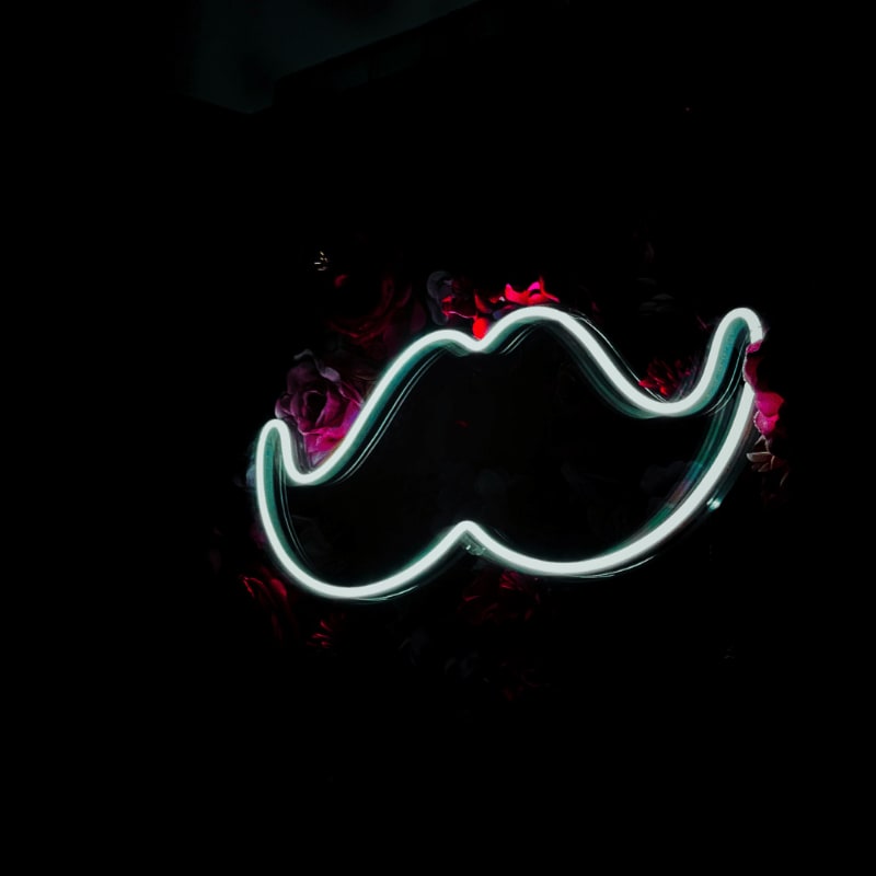 a neon moustache on a black background