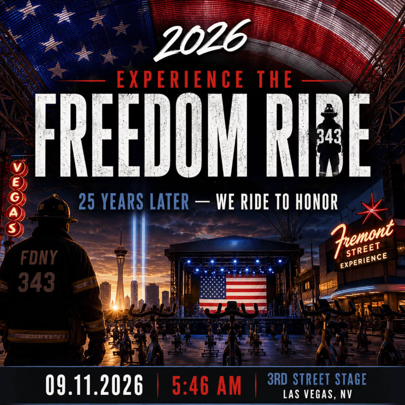 A firefighter stands in the foreground facing a stage with an American flag and rows of stationary bikes, set against a backdrop of the Las Vegas skyline and a large American flag.
