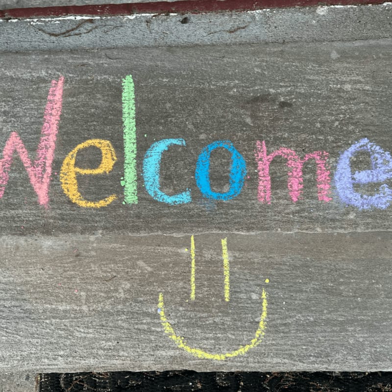 a welcome sign with a smiley face drawn on it