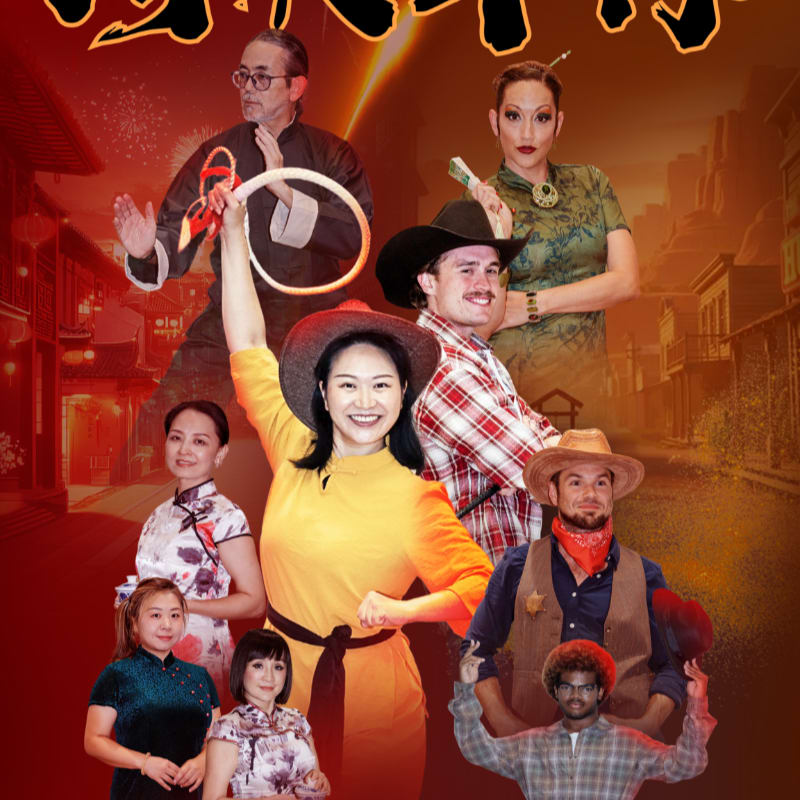 A group of performers in various costumes, including traditional Chinese attire and cowboy outfits, pose in front of a blurred background of a street scene with glowing lights.