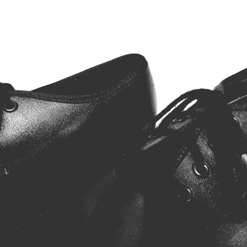 a pair of black shoes sitting on top of a wooden floor