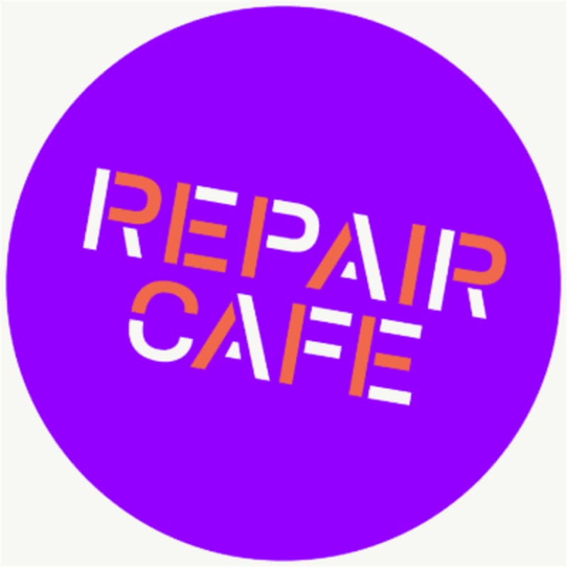 A purple circle with the words "REPAIR CAFE" in orange and white letters is set against a light gray background.