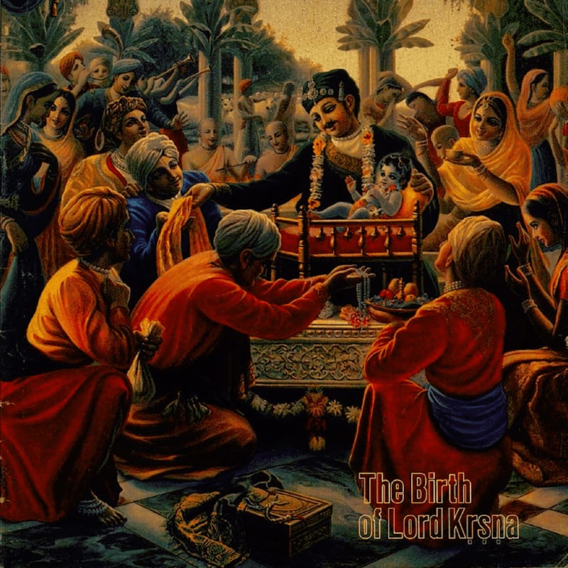 A crowd of people in vibrant attire gather around a cradle holding a baby in the foreground, while a grand, ornate building with pillars and lush greenery forms the background.