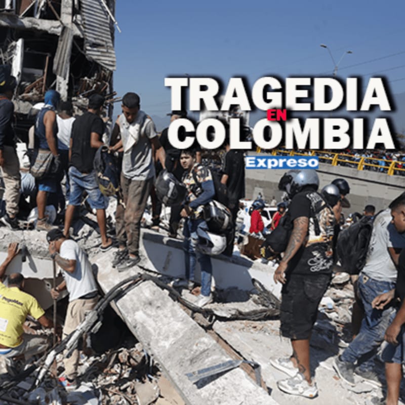 People stand amidst the rubble of a collapsed building in the foreground, with a blurred background of more destruction and onlookers.