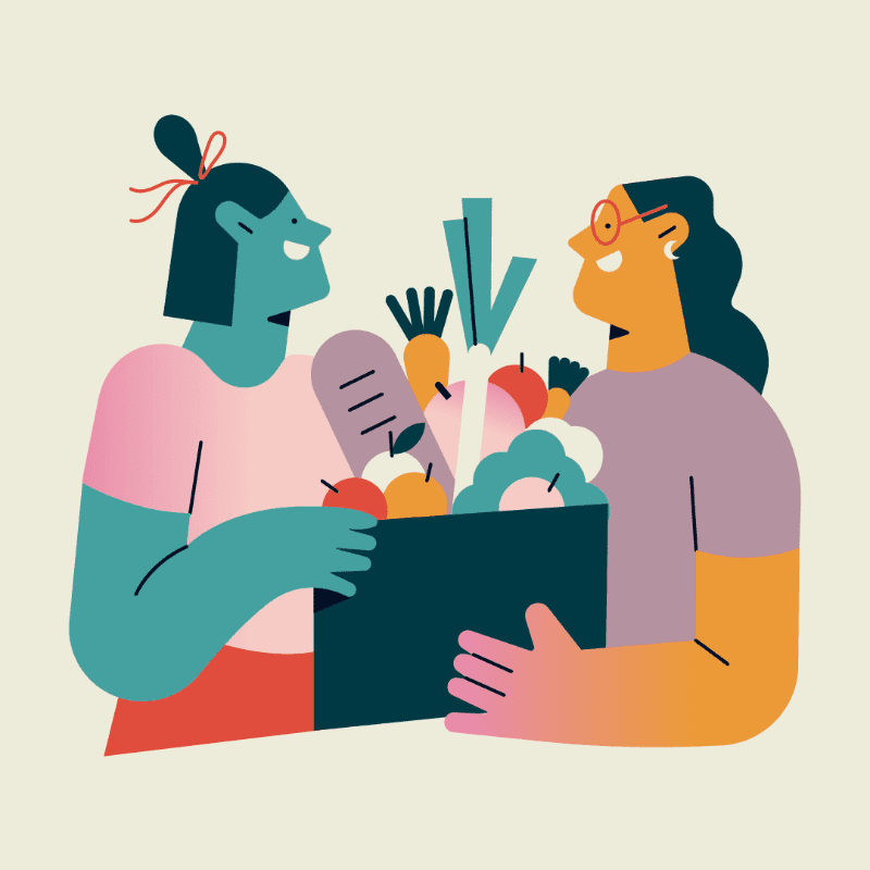Two people exchange a box of groceries against a plain background.